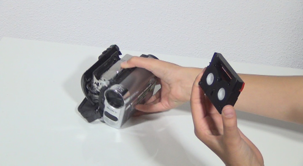 Eine Kassette wird aus einer Videokamera genommen.